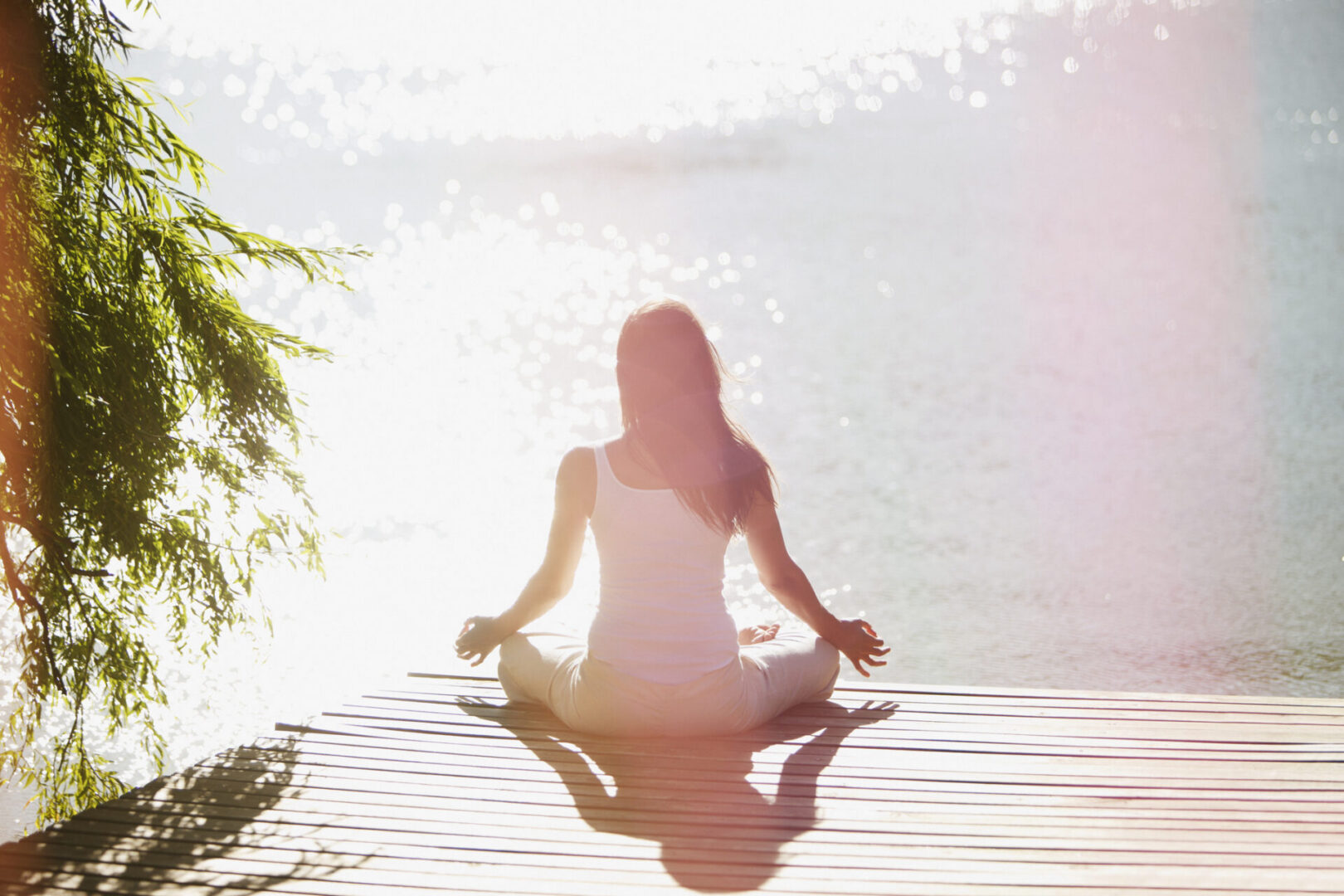 Woman practicing yoga on pier