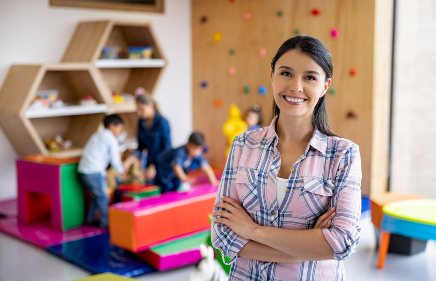 Portrait of a happy Latin American elementary school teacher smiling in the classroom and looking at the camera