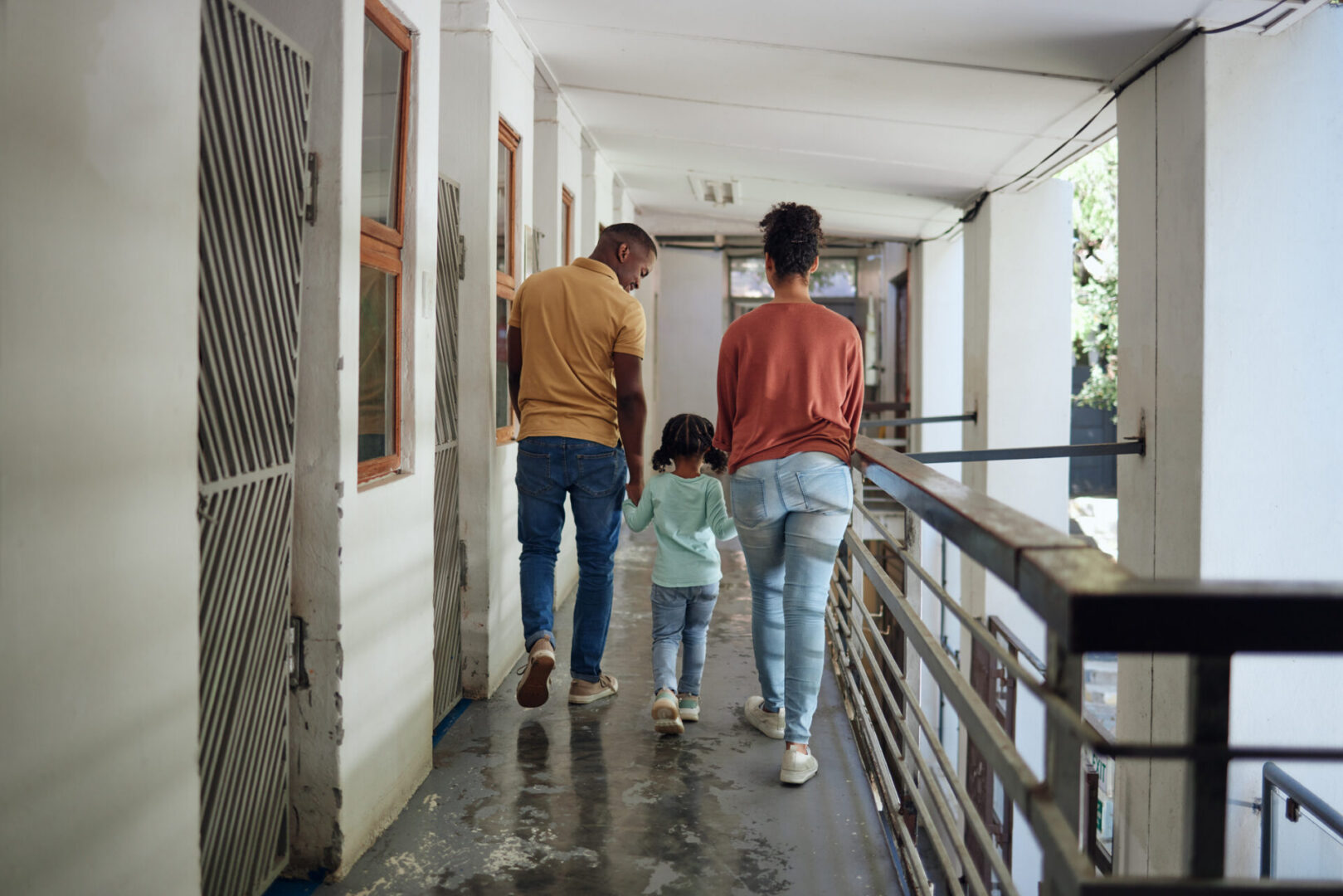 Black family, children and animal shelter with a girl, mother and father walking together on a balcony. Kids, volunteer and charity with a man, woman and daughter holding hands at a rescue center