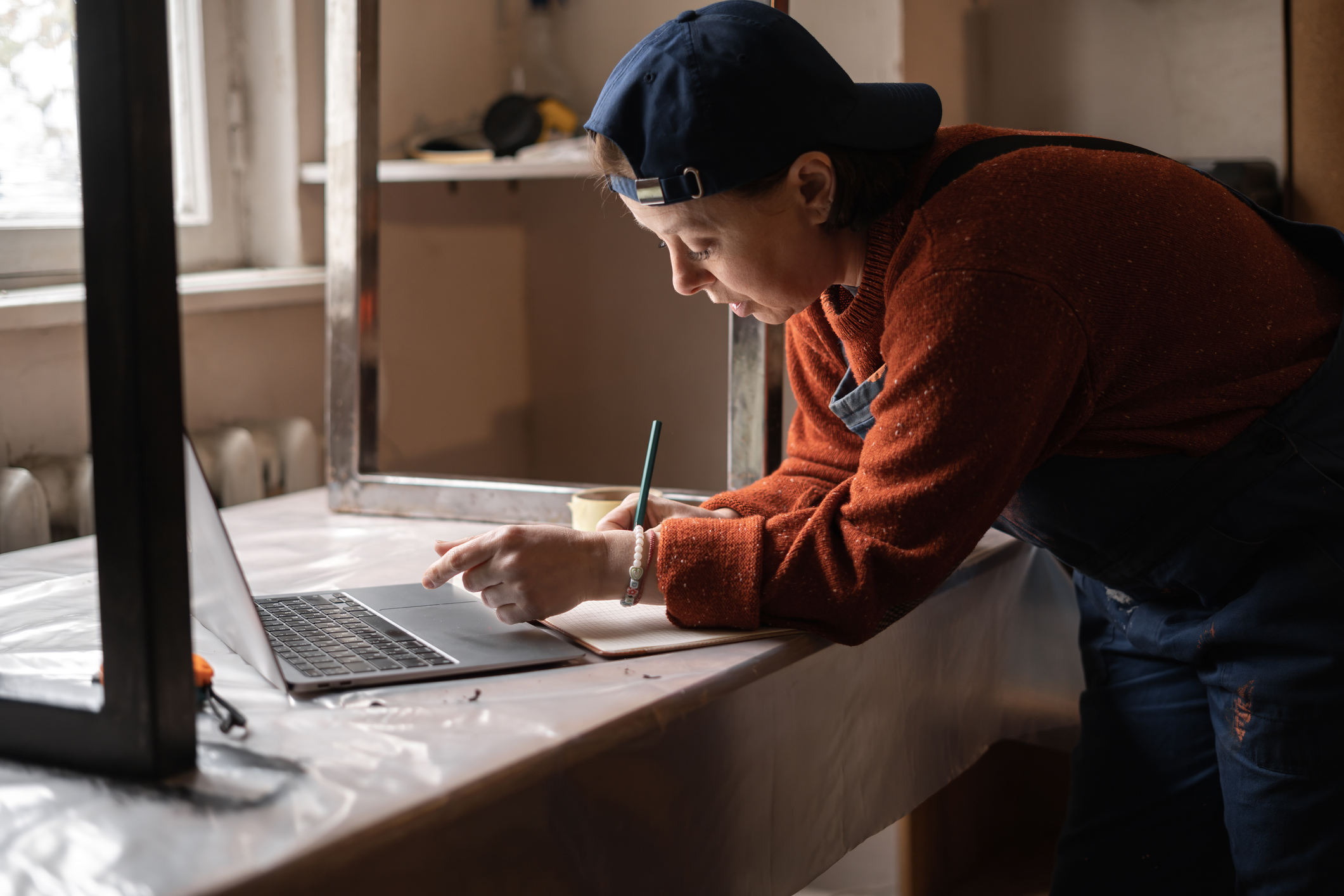 Business woman or Craftswoman working using a laptop in the garage. Mechanic at workshop. copy space